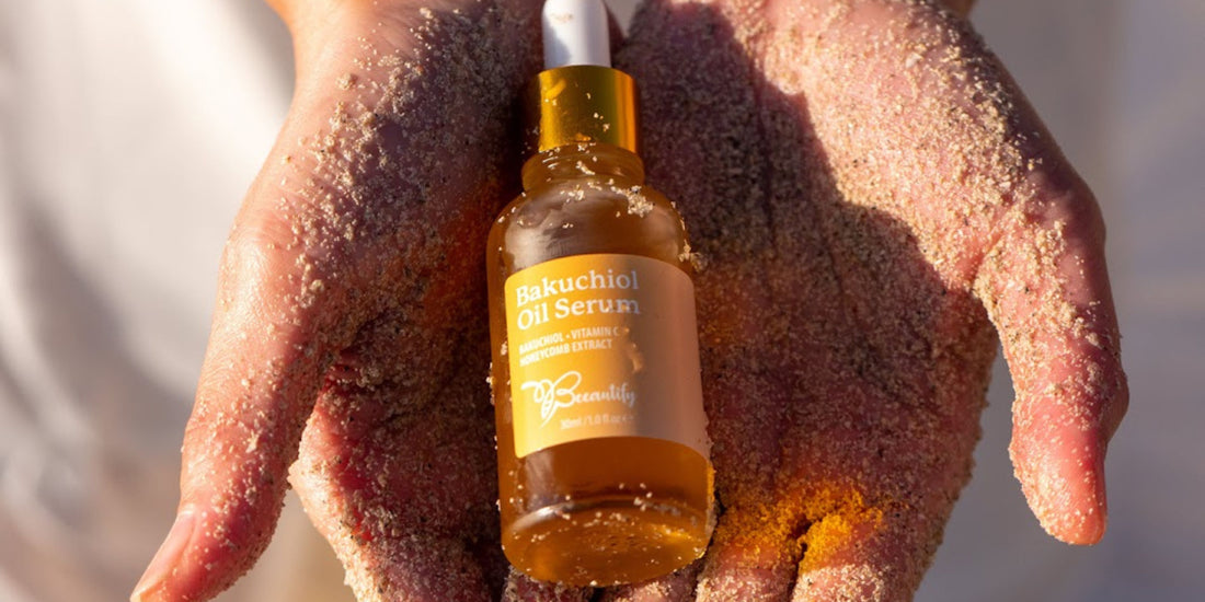 A bottle of Bakuchiol Oil Serum in sandy hands