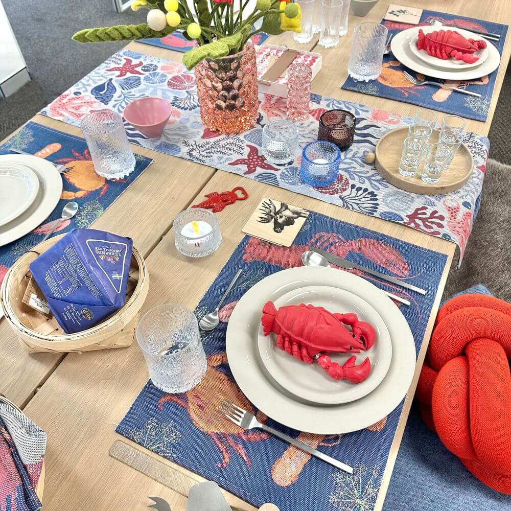 Dining table set with lobster-themed place settings and decor.