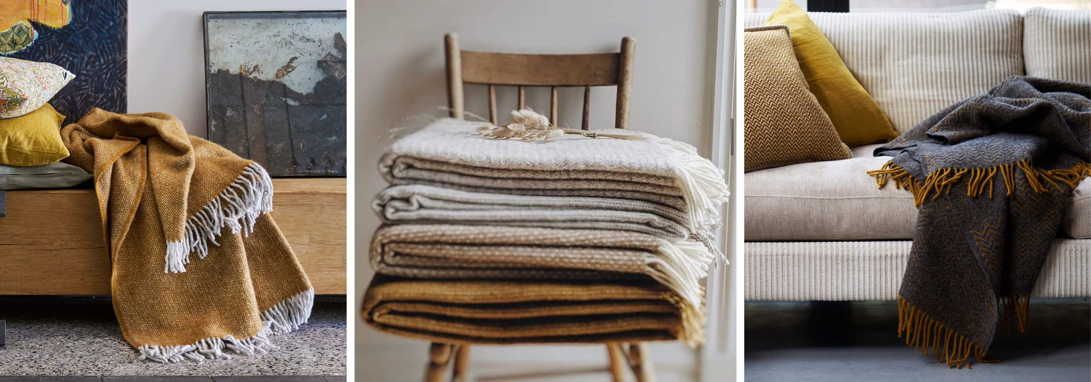 Collection of blankets in various colours and textures on a table and couch.