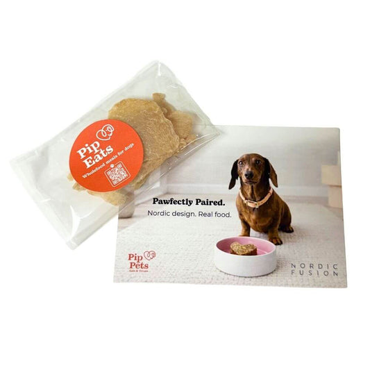 Pip Eats sample dog treats package with a dog sitting next to a bowl of food on a white background